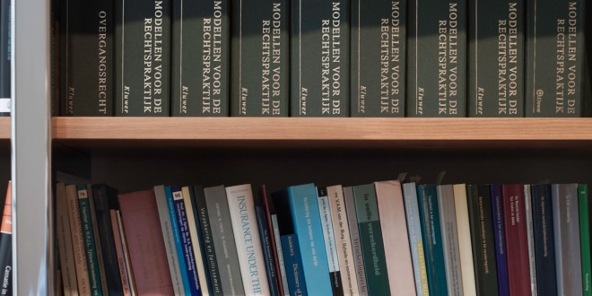 Een boekenkast vol boeken over de rechtspraktijk.